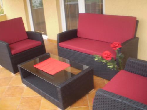 two chairs and a table with flowers in a room at Villa Jelena in Zadar