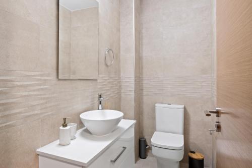 a bathroom with a white toilet and a sink at Ethereal Residence by Nomads in Paphos