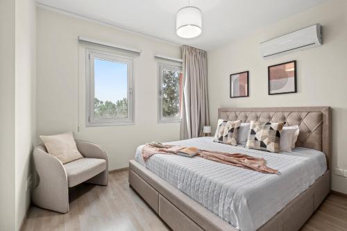a bedroom with a large bed and a chair at Ethereal Residence by Nomads in Paphos