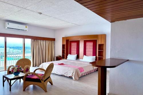 a bedroom with a bed and a table and chairs at Pailyn Hotel Phitsanulok in Phitsanulok