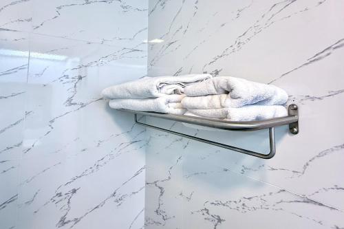 a towel rack in a bathroom with white marble walls at Pailyn Hotel Phitsanulok in Phitsanulok
