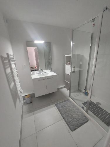 une salle de bain blanche avec douche et lavabo dans l'établissement Cimes A401, à Briançon