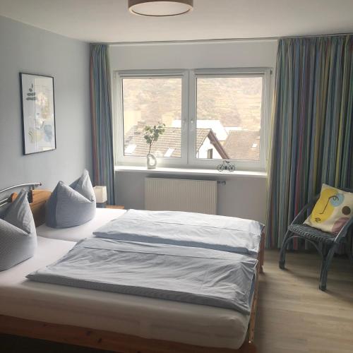 a bedroom with a bed and a window and a chair at Grandezza Ferienwohnungen Erpeldinger in Ellenz-Poltersdorf