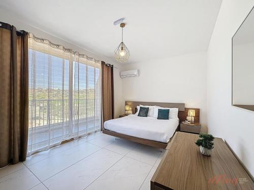 a bedroom with a bed and a large window at Stylish Seaview Retreat in St Pauls Bay in St. Paul's Bay
