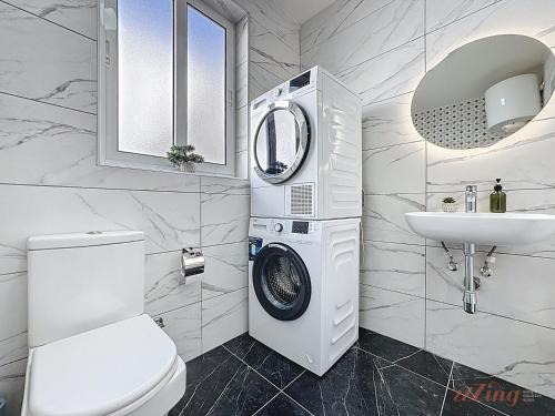 a white bathroom with a washing machine and a sink at Stylish Seaview Retreat in St Pauls Bay in St. Paul's Bay