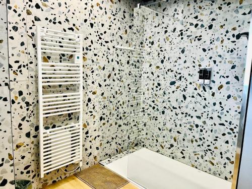 a bathroom with a patterned wall with a white shelf at Appartement cosy ambiance Malibu dans résidence avec piscine 2 pers 1 chambre in Neuf-Mesnil