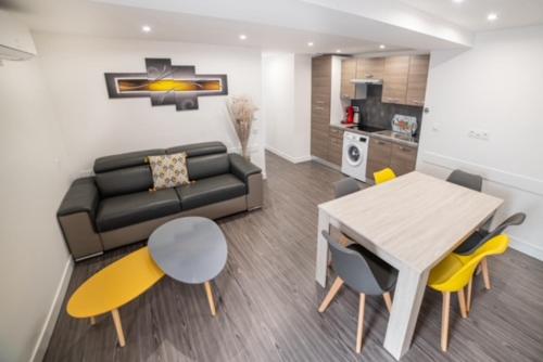 a living room with a couch and a table and chairs at Appartement Sun GroupamaLyon Eurexpo in Meyzieu