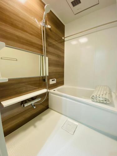 a bathroom with a tub and a mirror at Villa KENZO JR弁天町駅4分地下鉄駅6分 USJ 梅田 大阪城公園直通 駐車場付きモダン一軒家 in Osaka