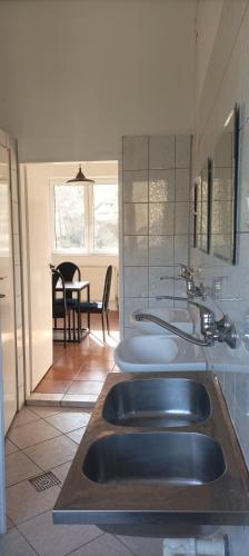 a bathroom with three sinks and a dining room at Magura Camp in Małastów