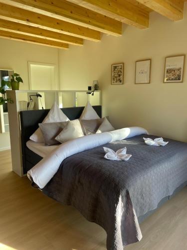 a large bed with two white flowers on it at Gartenlodge im Grünen in Feuerscheid