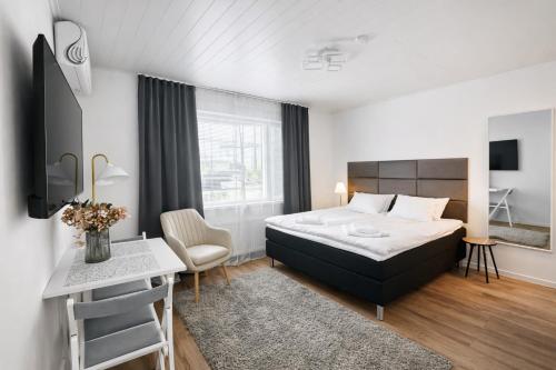 a bedroom with a bed and a table and a desk at Katariina Apartments in Kotka