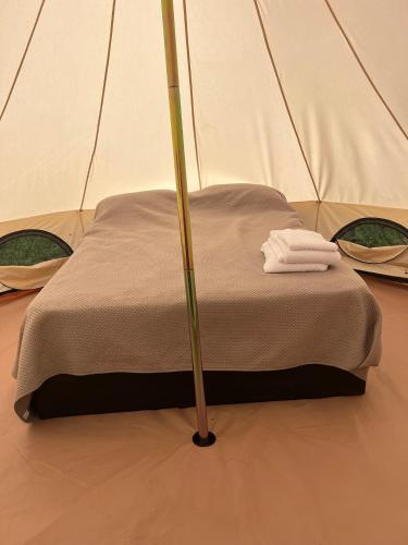 a bed in a tent with a towel on it at Sauron Adventure in Cuesta Blanca