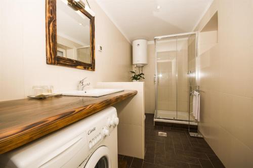 a bathroom with a sink and a washing machine at House Elena in Lindar