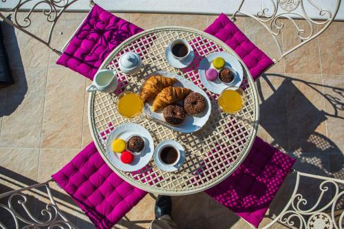 a table with a plate of donuts and cups of coffee at Villa Eni in Primošten