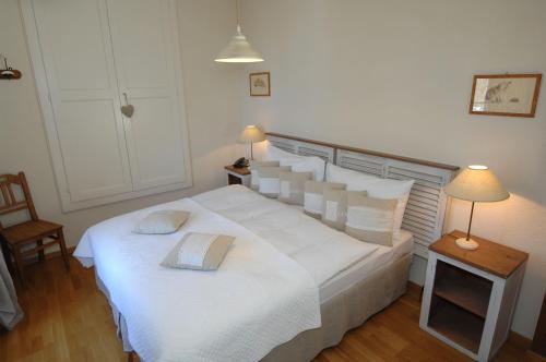 Un dormitorio con una cama blanca con un libro. en Auberge de la Gare, en Grandvaux