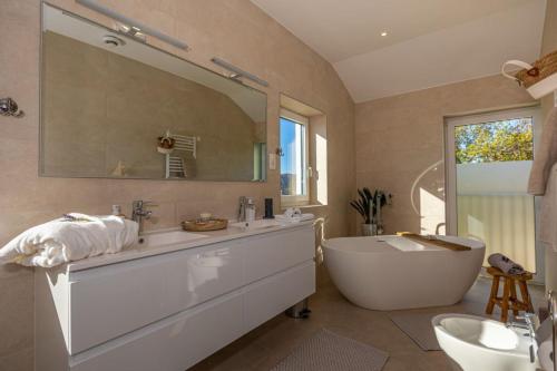 a bathroom with a tub and a large mirror at Villa Jackie in Bribir