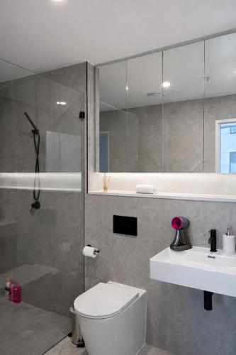 a bathroom with a shower and a toilet and a sink at Waterfront High Rise 5 Beds 2 Car Parks in Sydney
