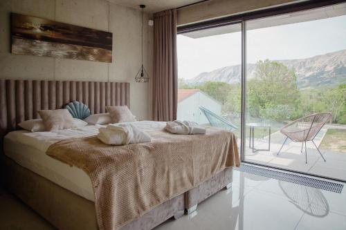 a bedroom with a bed and a large window at Villa Lorkia in Baška