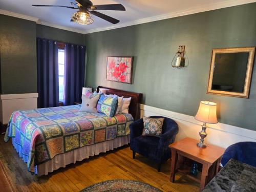 a bedroom with a bed and a chair at Firehouse Inn in Barre