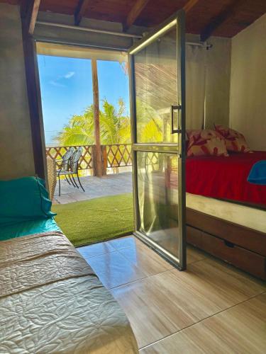 a room with a bed and a sliding glass door at Paradise BH in Maizal