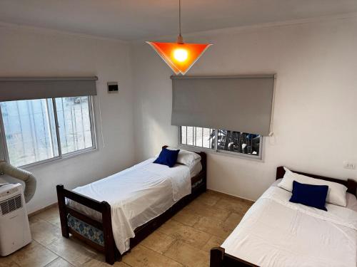 a bedroom with two beds and a light fixture at Casas Villa azul in Tanti