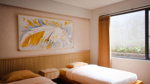 a bedroom with two beds and a large window at Miracle Hotel Cianjur in Pasirhayam