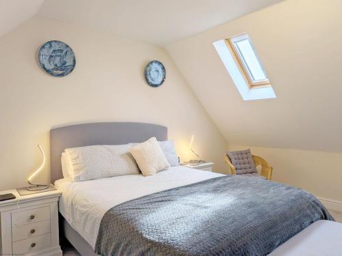 a bedroom with a bed and two clocks on the wall at Pears Grove - Southbourne in Emsworth