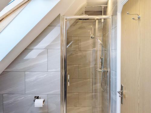 a shower with a glass door in a bathroom at Pears Grove - Southbourne in Emsworth