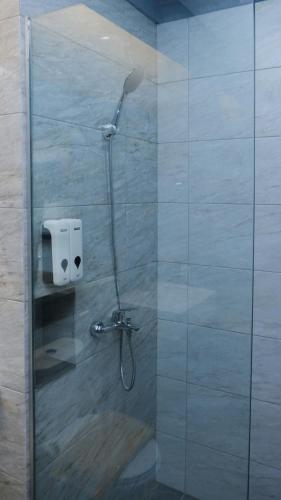 a shower with a shower head in a bathroom at Miracle Hotel Cianjur in Pasirhayam