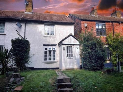 a white house with a white door in a yard at Parkgate Cottage Countryside Stay at Chelsfield Retreat in Chelsfield