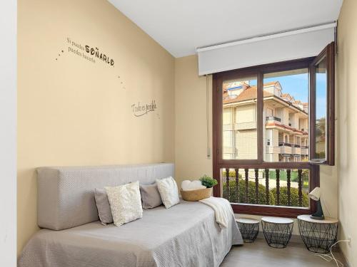 a living room with a couch and a window at Apartamento en la playa con piscina - Azcona 6004 in Noja