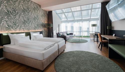 a hotel room with two beds and a living room at Hotel Arkadia in Friedrichsdorf