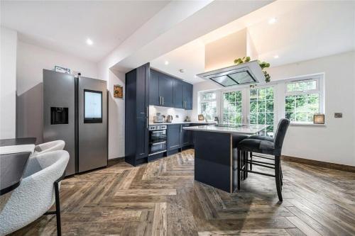 a kitchen with blue cabinets and a black counter top at Parkgate Cottage Countryside Stay at Chelsfield Retreat in Chelsfield