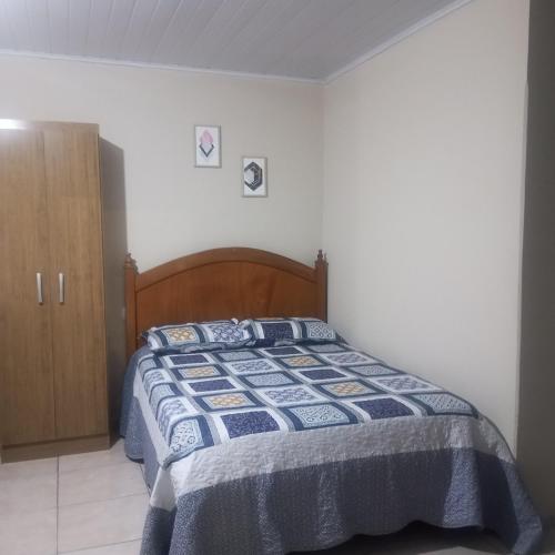 a bedroom with a bed with a blue comforter at Microcasa na região do lago in Cascavel