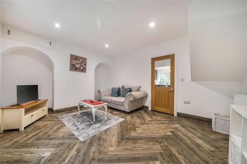 a living room with a couch and a tv at Parkgate Cottage Countryside Stay at Chelsfield Retreat in Chelsfield