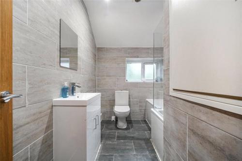 a bathroom with a toilet and a sink and a tub at Parkgate Cottage Countryside Stay at Chelsfield Retreat in Chelsfield
