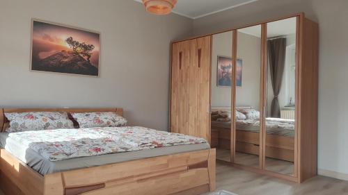 a bedroom with a wooden bed and a mirrored cabinet at Ferienwohnung Stadtblick Königstein in Königstein an der Elbe