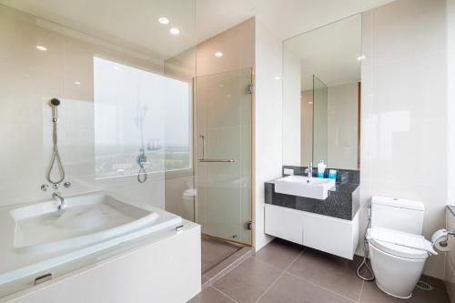 a bathroom with a tub and a toilet and a sink at White Sands Beachfront l 2BR Condo with Ocean View in Na Jomtien