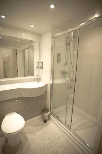 a bathroom with a shower and a toilet and a sink at The Welcome Inn in Rotherham