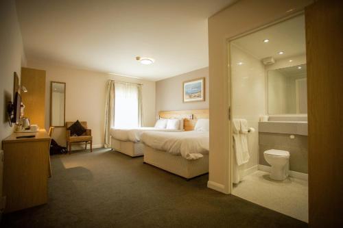 a hotel room with a bed and a bathroom at The Welcome Inn in Rotherham