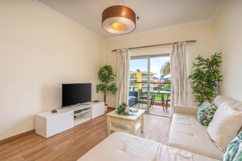 a living room with a couch and a tv at #010 Marina View Apartment Pool & Balcony in Albufeira