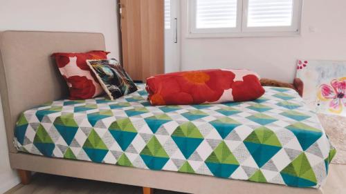 a bed with a comforter and pillows on it at Studioraum nähe Koblenz in Sankt Sebastian