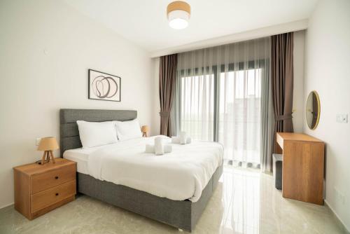 a bedroom with a large white bed and a window at Riverside Life Residence in Trikomo