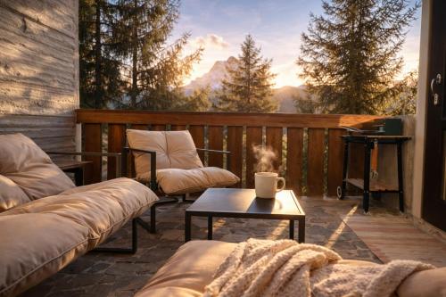 a patio with couches and a table with a view at Chalet DolceVista con SPA, vicino a Cortina d'Ampezzo in Borca di Cadore