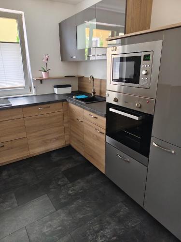 a kitchen with stainless steel appliances and wooden cabinets at Alpenblick in Trofaiach