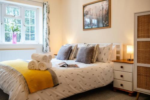 a bedroom with a bed with a teddy bear on it at Wynmere Cottage in Chipping Norton
