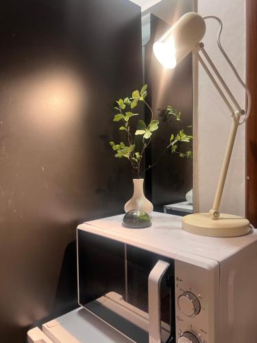 a desk with a lamp and a plant on it at Stay Us 3151 in Seongnam