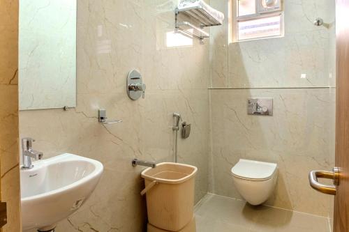 a bathroom with a sink and a toilet and a mirror at Hotel M S Chola in Chennai