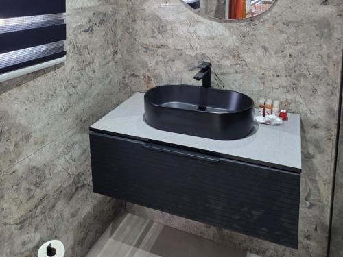 a bathroom with a black sink on a counter at Bush Diamond Lodge in Cullinan