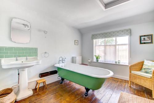 a bathroom with a green tub and a sink at 4 Bed in Walpole oc-brof in Walpole